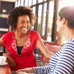 Two female friends talking at a coffee shop